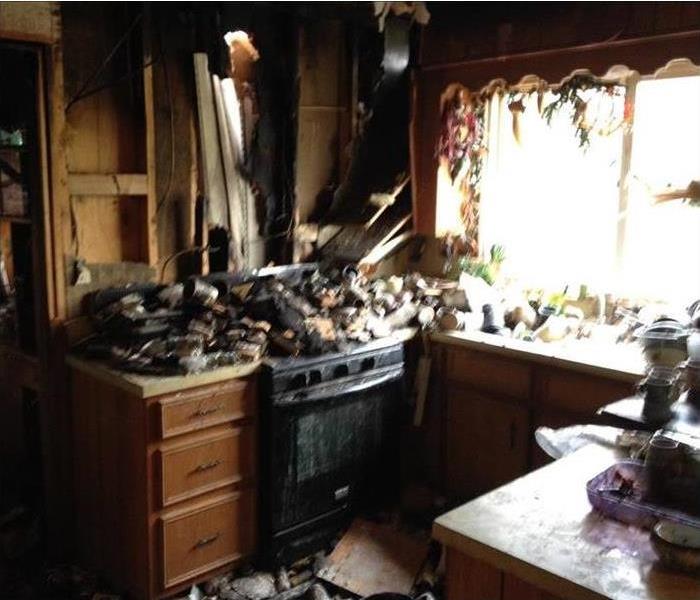 burned kitchen, debris piled up, ruined cabinets