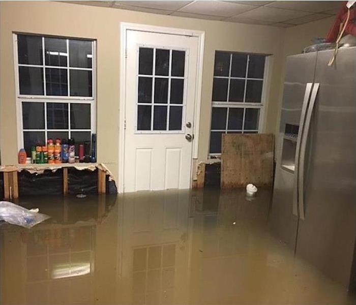 muddy water inside the house by a fridge