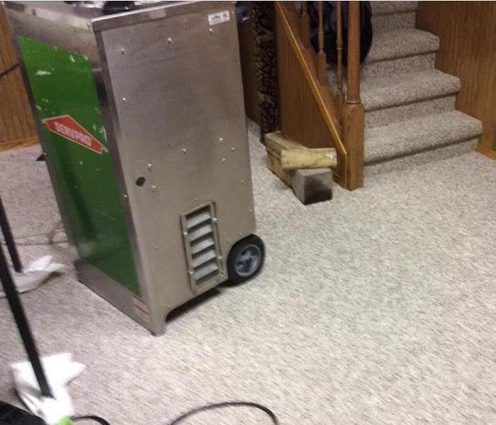 dehumidifier working on the carpet by stairs