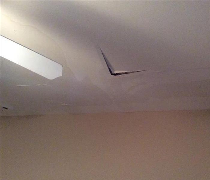 water damaged ceiling showing stains and split at panel seams