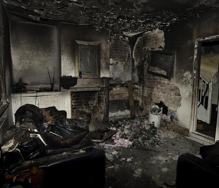 Inside room of fire damage home. Heavy damage; debris on floor; burnt possessions.