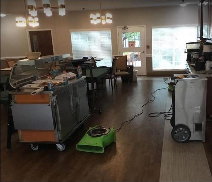 Inside view of water damaged café, SERVPRO restoration equipment being used